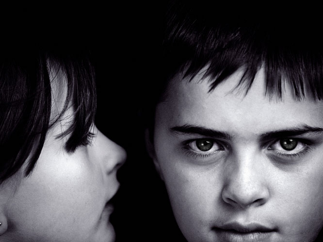 girl whispers to boy